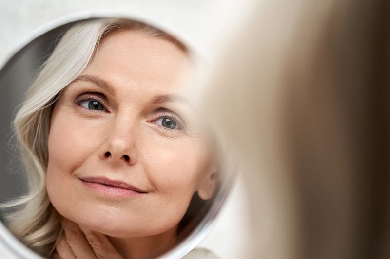 Mature skin in a hand mirror